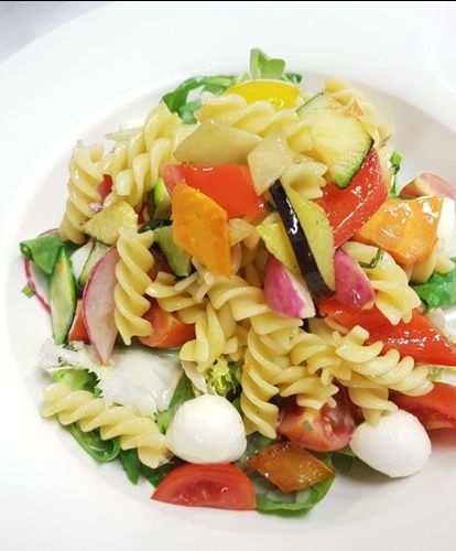 Insalata di pasta tiepida su verdure wok