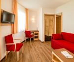 Living room of the Junior-Suite with TV, couch and desk